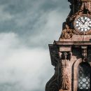 brown-concrete-clock-tower-under-white-clouds-
