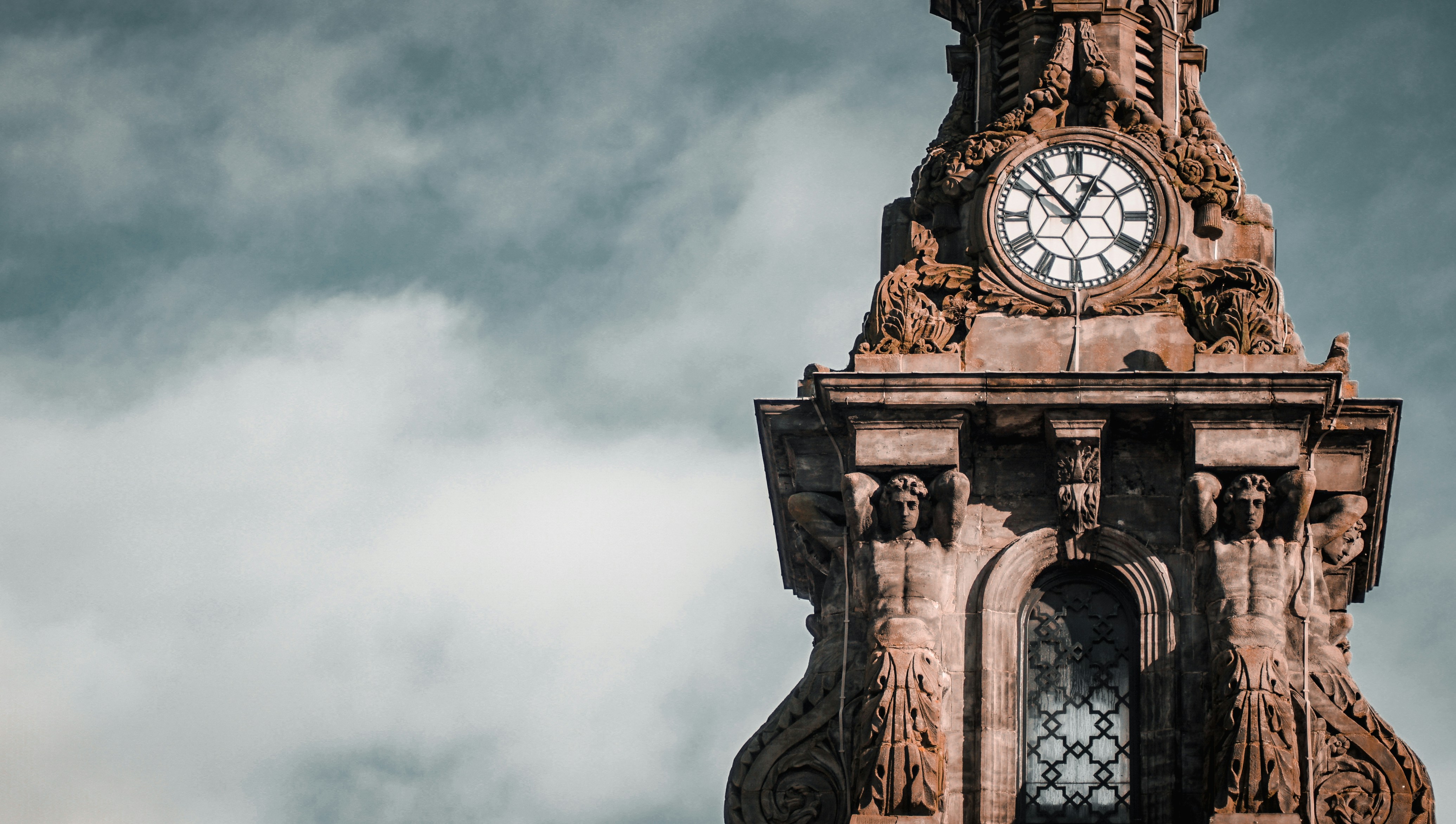 brown-concrete-clock-tower-under-white-clouds-