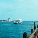 a-boat-traveling-in the sea-next-to-a-pier