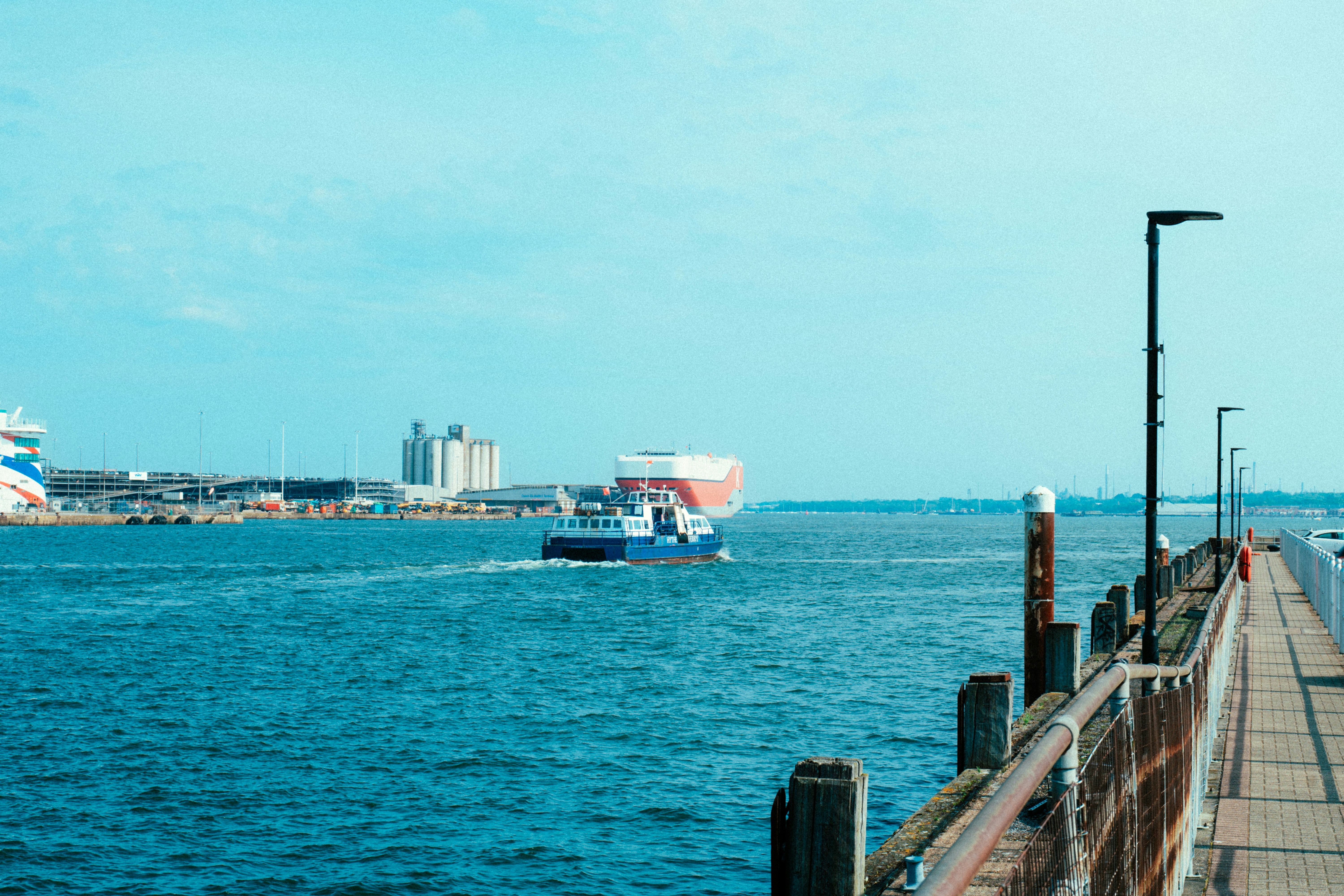 a-boat-traveling-in the sea-next-to-a-pier