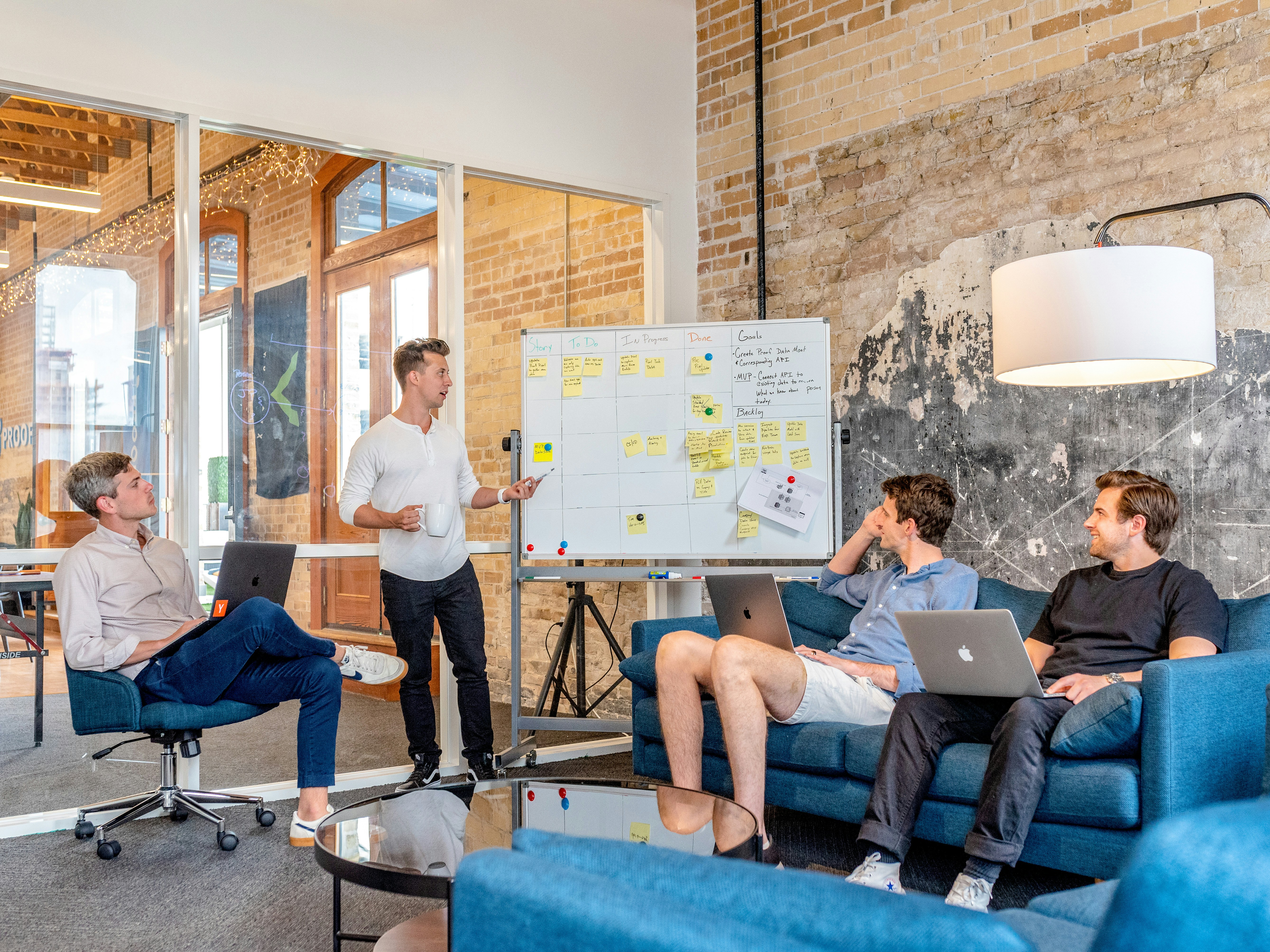 4 men gathered round a white board