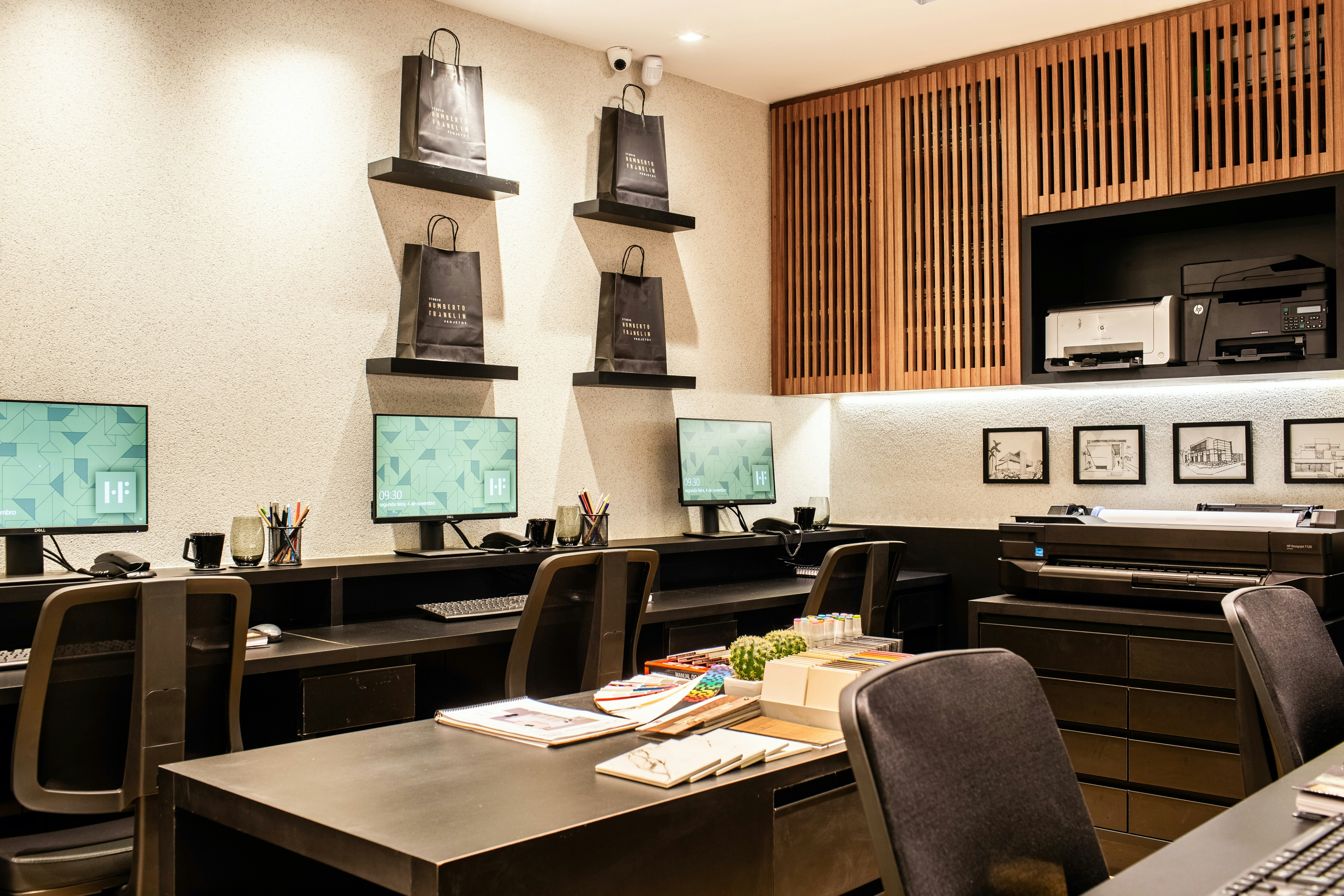 banks of desks in a room with pictures on the wall