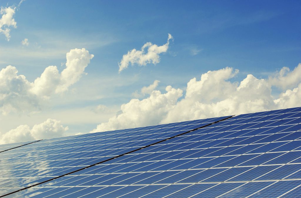 A row of solar panels against a bright summer sky