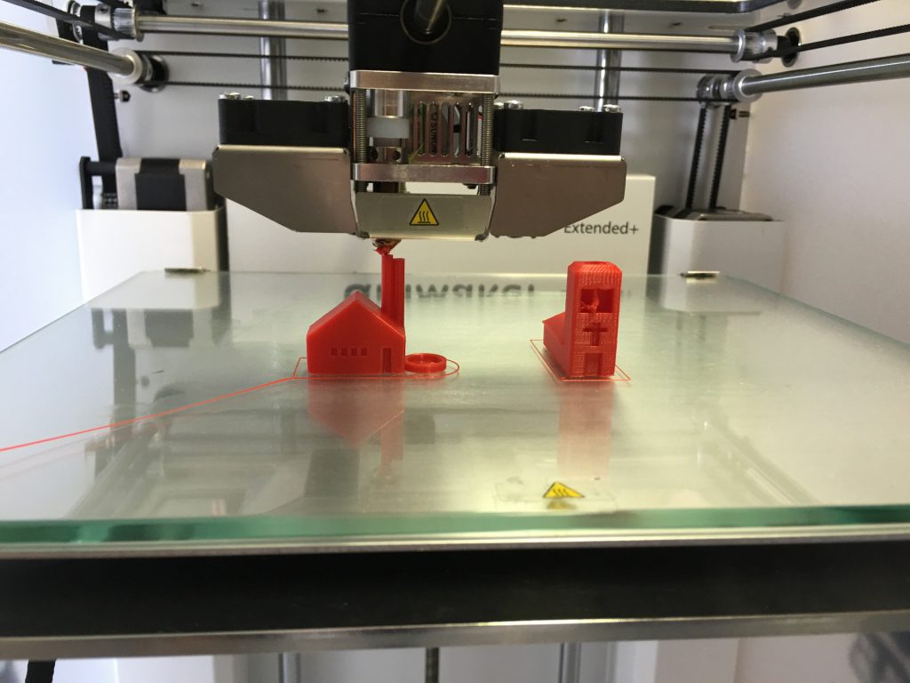 Small buildings being created in a 3D printer