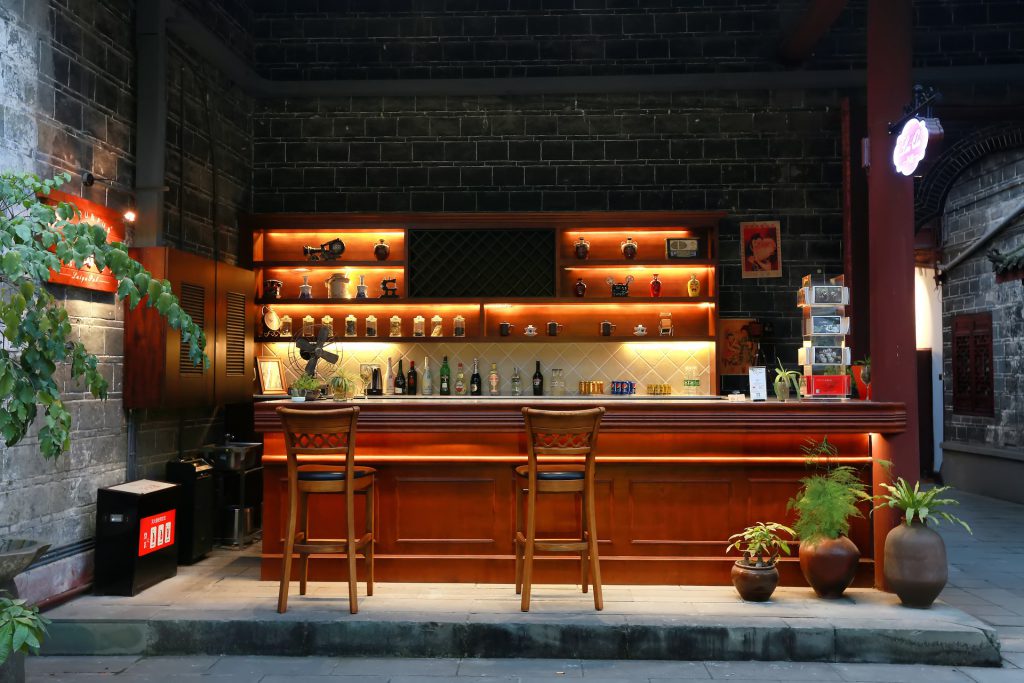 A lavish, ambient bar with two chairs that'd be romantically placed if they weren't so far apart. 