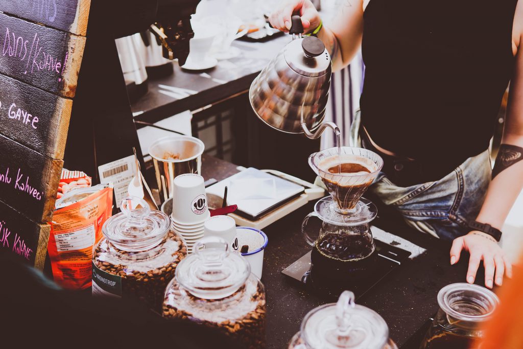 A woman - or perhaps, a breasted man? - pours an elaborate coffee in a foreign cafe