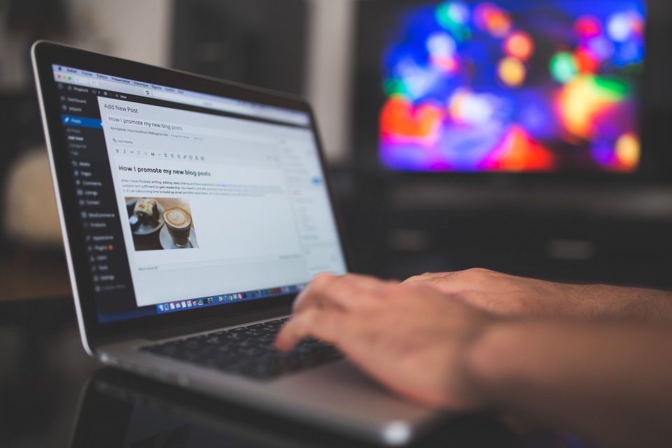 hands typing on an open laptop