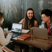 3 people sitting in front of laptops