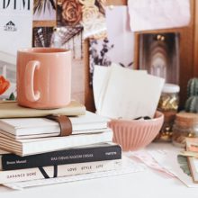 pile of books with a cup on top