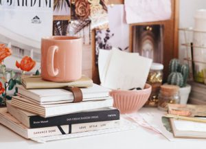 pile of books with a cup on top 