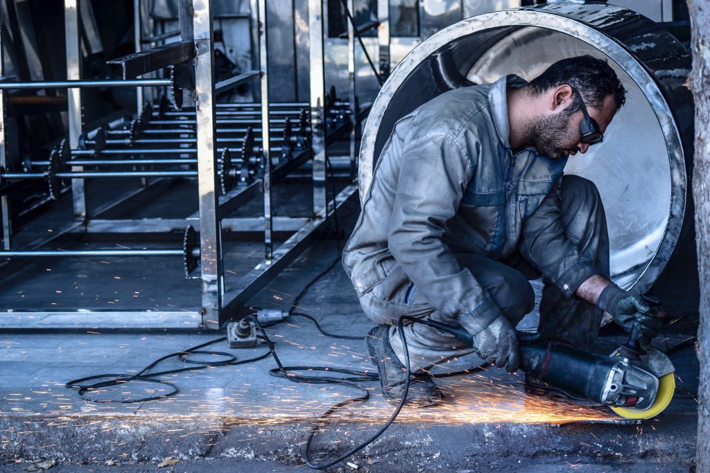 male welding metal on floor