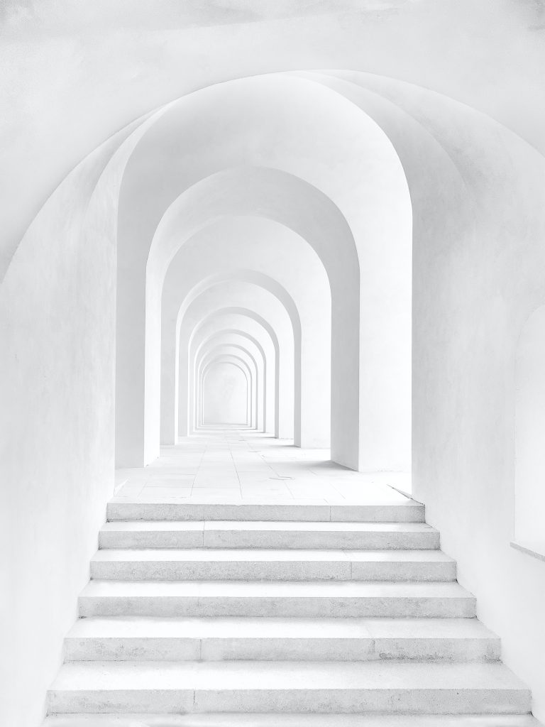 white archway in a white wall