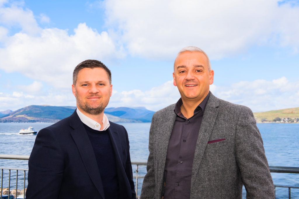 two men stood in front of a lake 