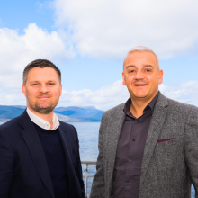 two men stood in front of a lake