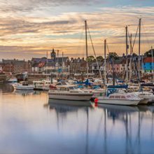 yachts in a marina with an evening sky