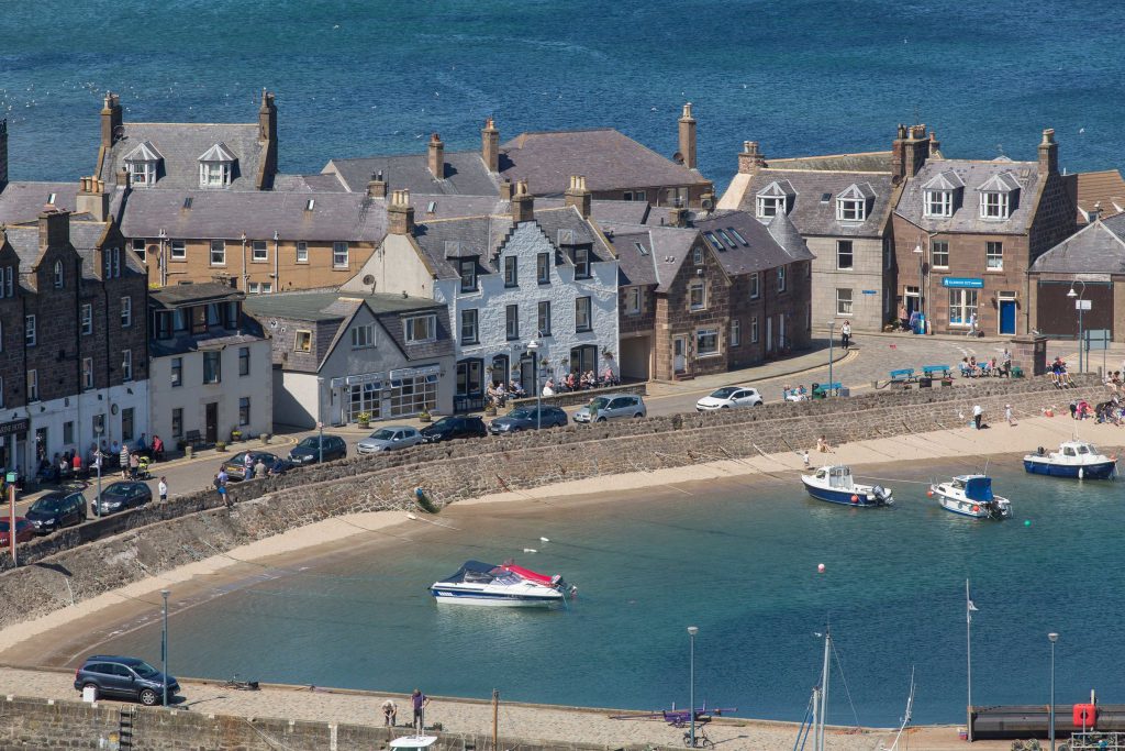 white building and building immediately to left in harbour setting