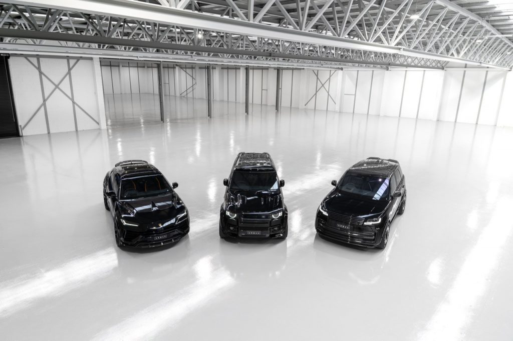 interior warehosue with 3 black cars in centre 