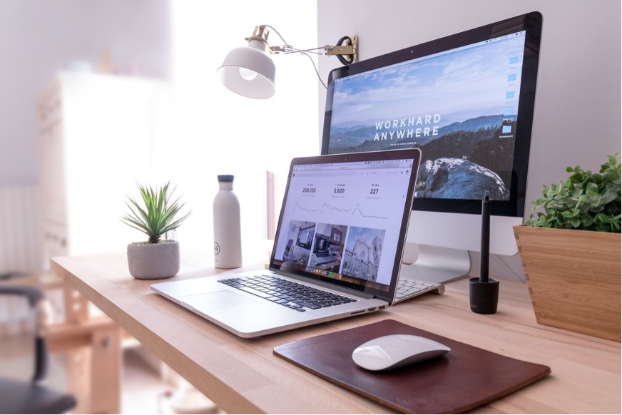 a laptop and monitor set out on a desk 