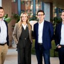 three men and one woman in business wear