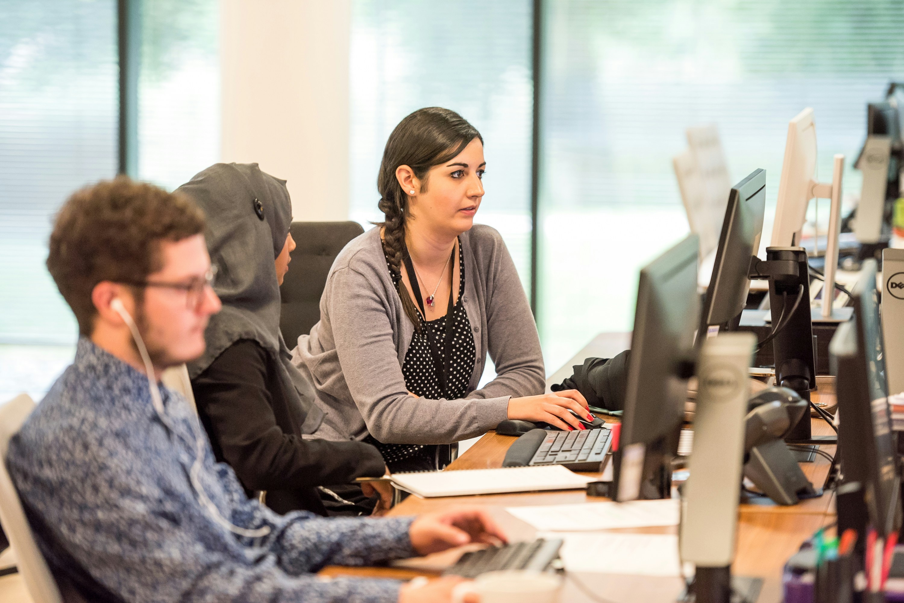 three people working on computers
