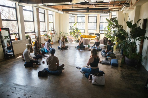 people sat in a circle in a yoga pose