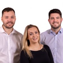 Two men and one woman posing for a photo