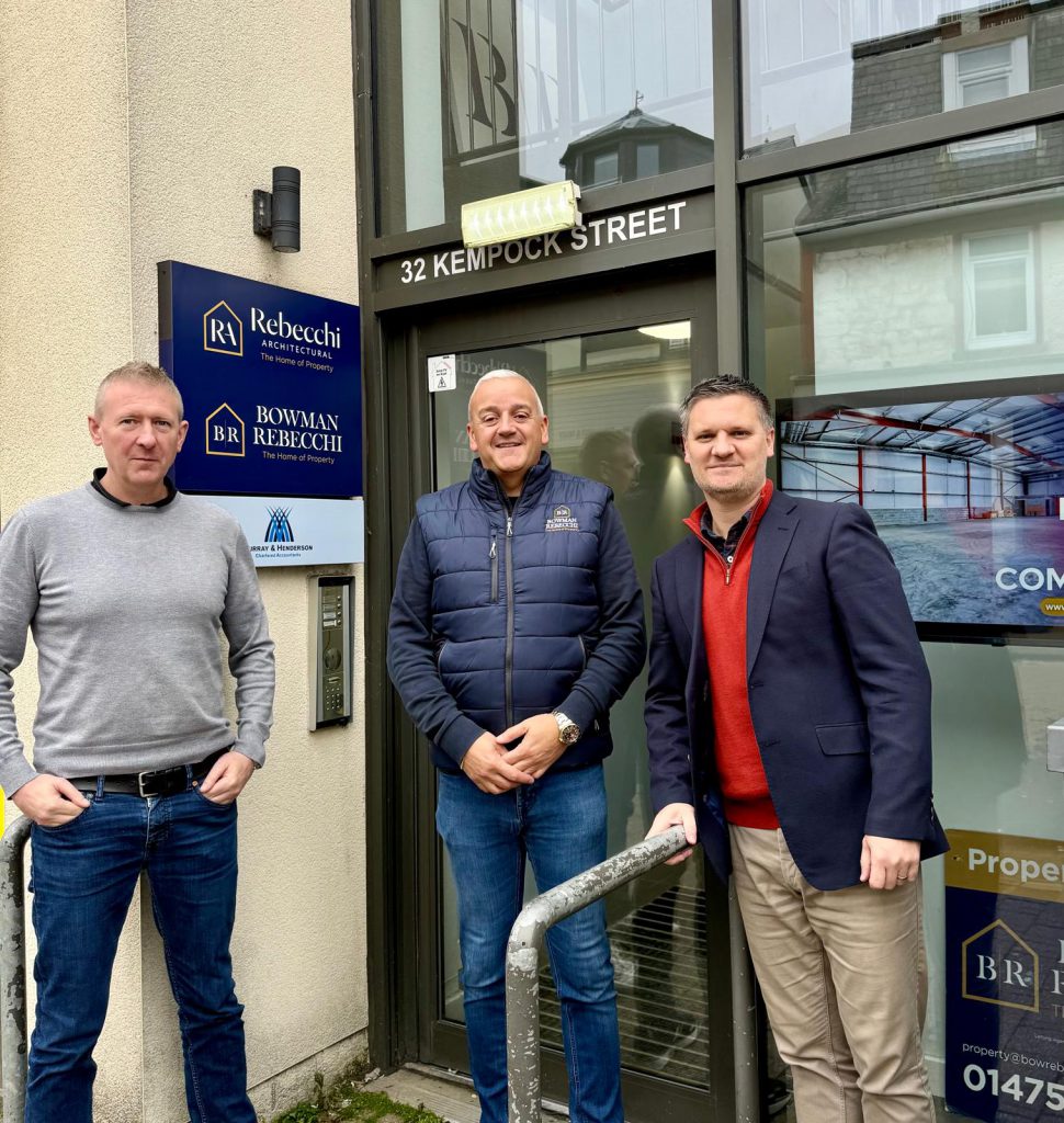 Three men in casual way standing at the door to an office