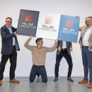 four men holding up logo's