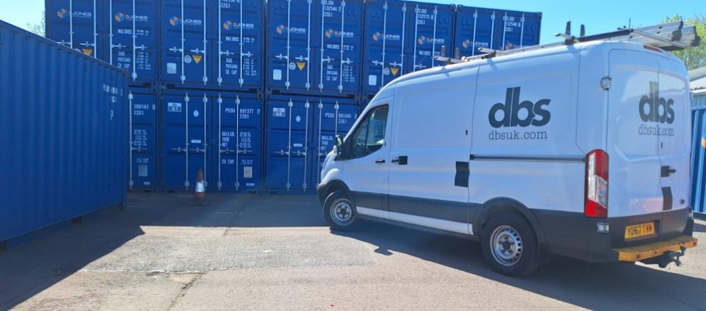 DBS van in front of storage containers