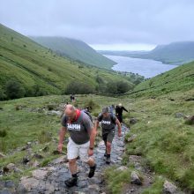 several men hiking up a hill