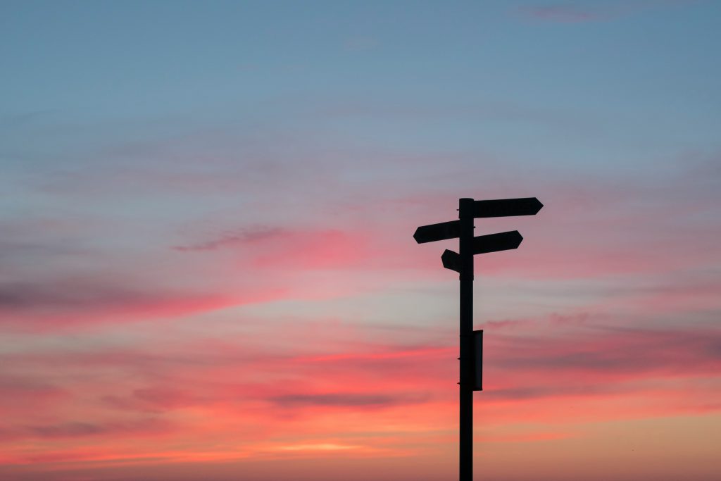 sunset scene with a silhouetted sign post 