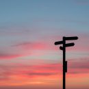 sunset scene with a silhouetted sign post