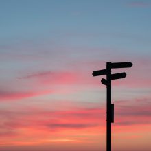 sunset scene with a silhouetted sign post